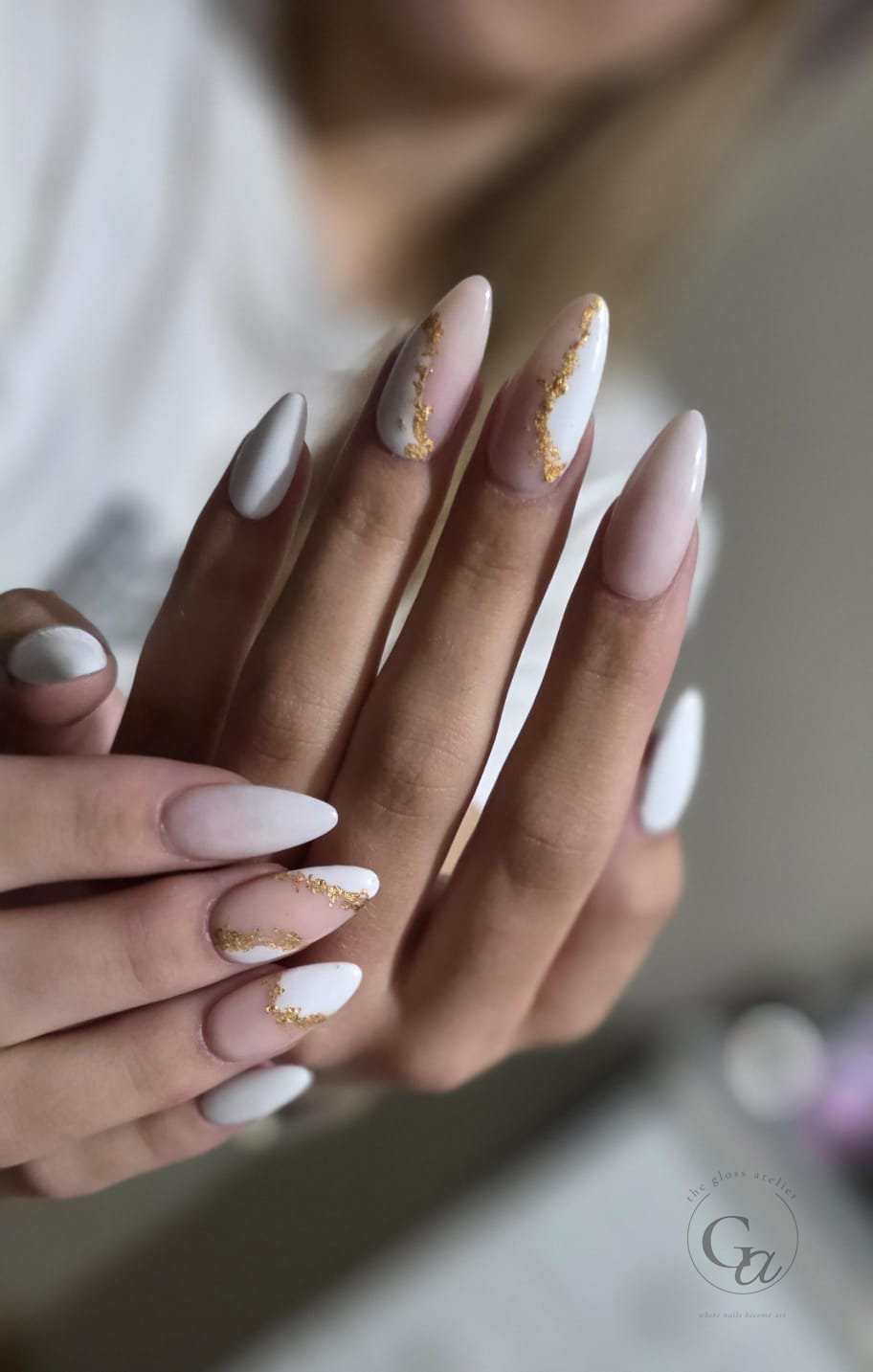 Milky white almond nails with hand-applied gold-leaf accents.