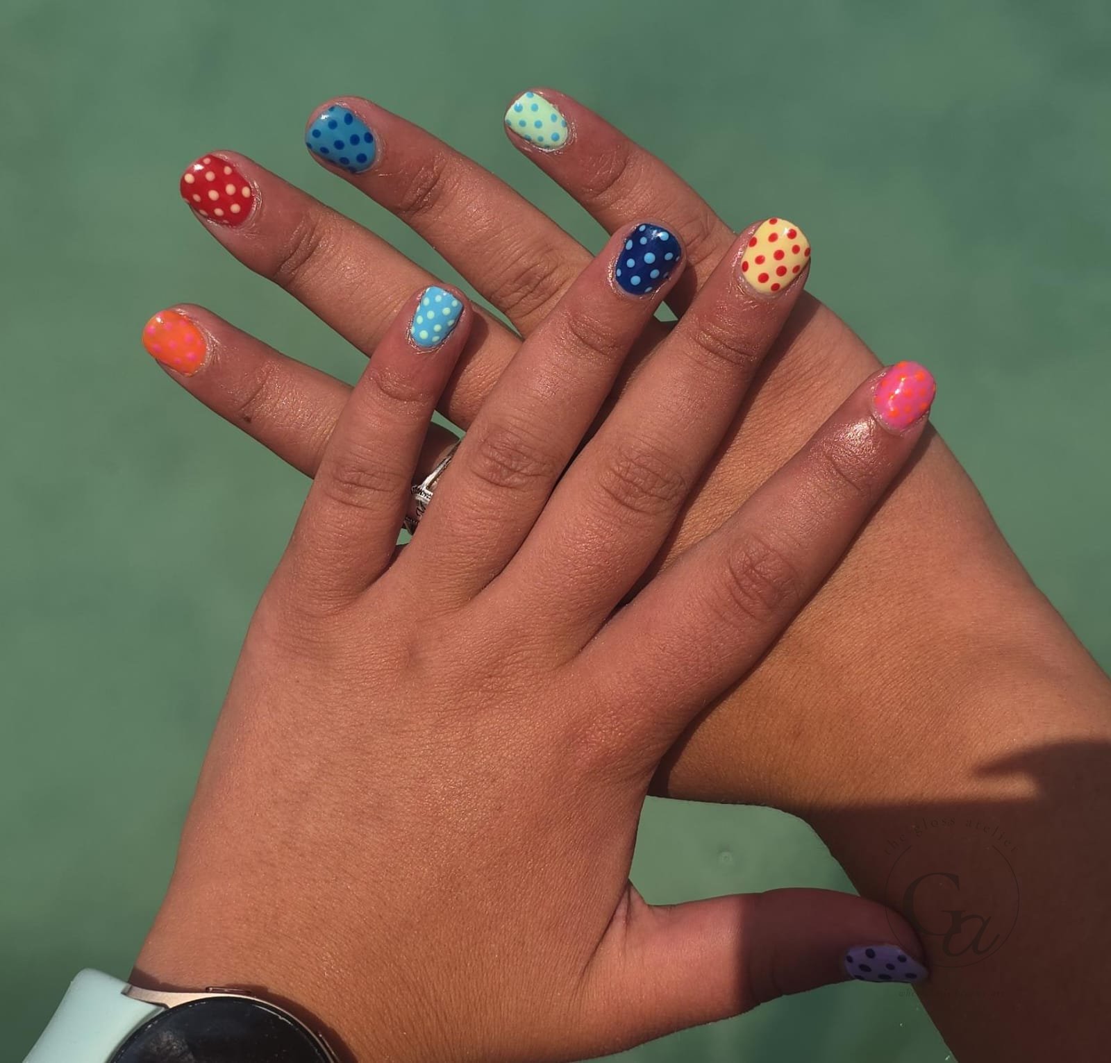 Short natural nails in multicolour polka dots.