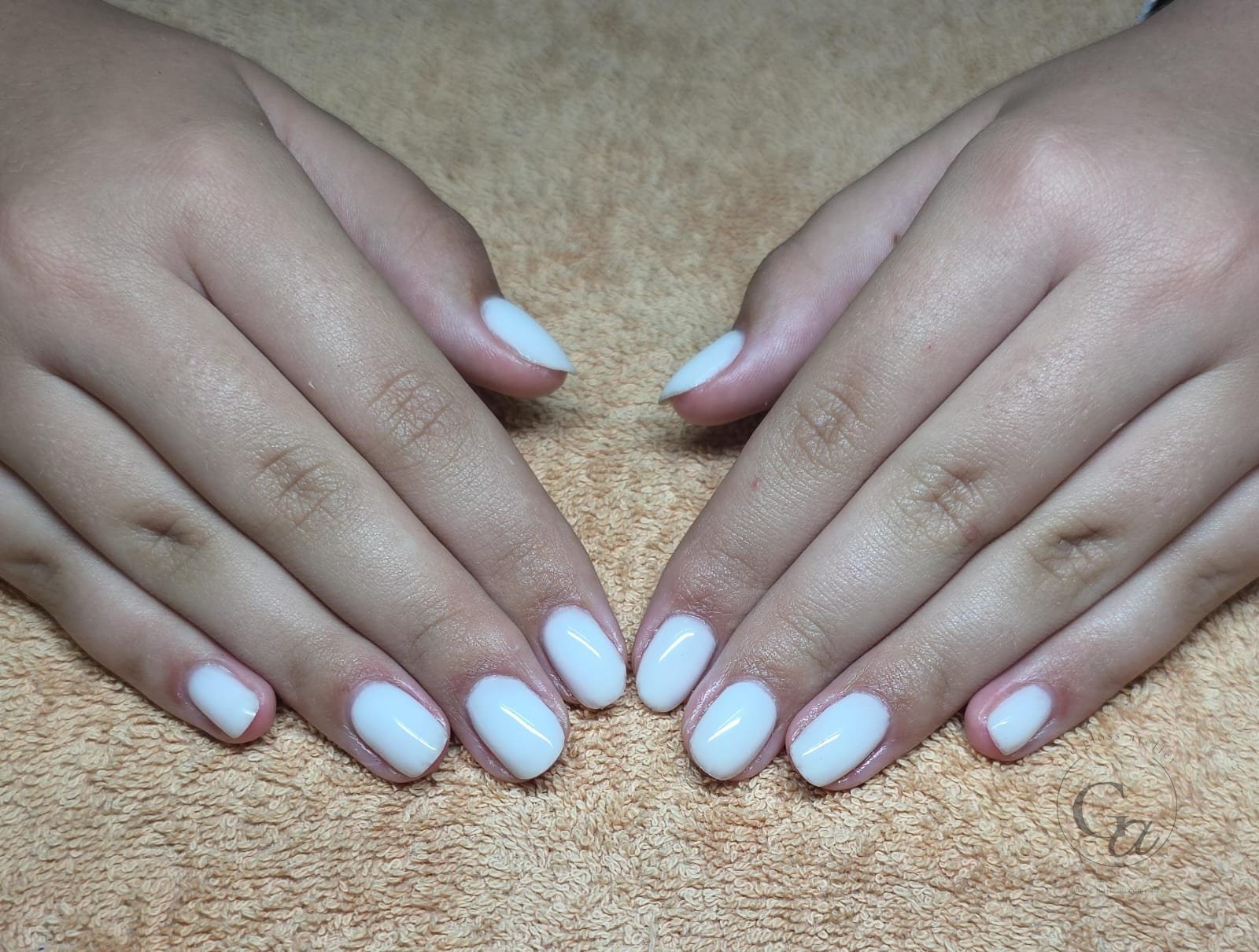 Milky white gel on short oval natural nails.