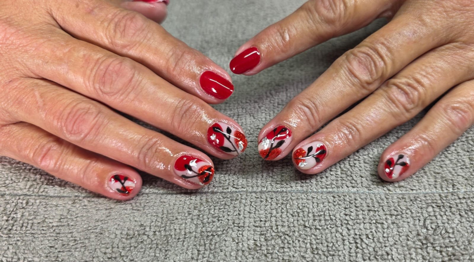 Hand-painted red poppies with black stems and glitter centres, with red accent nails.