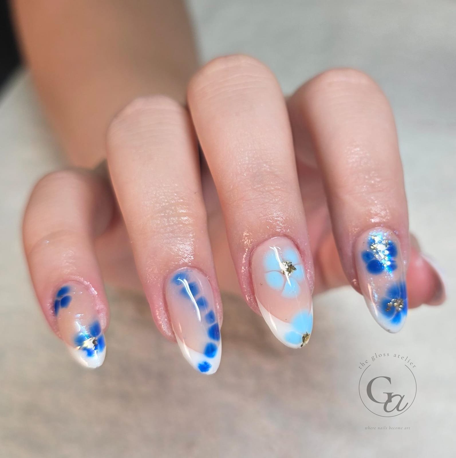 Blue watercolour flowers with gold leaf over white French tips.