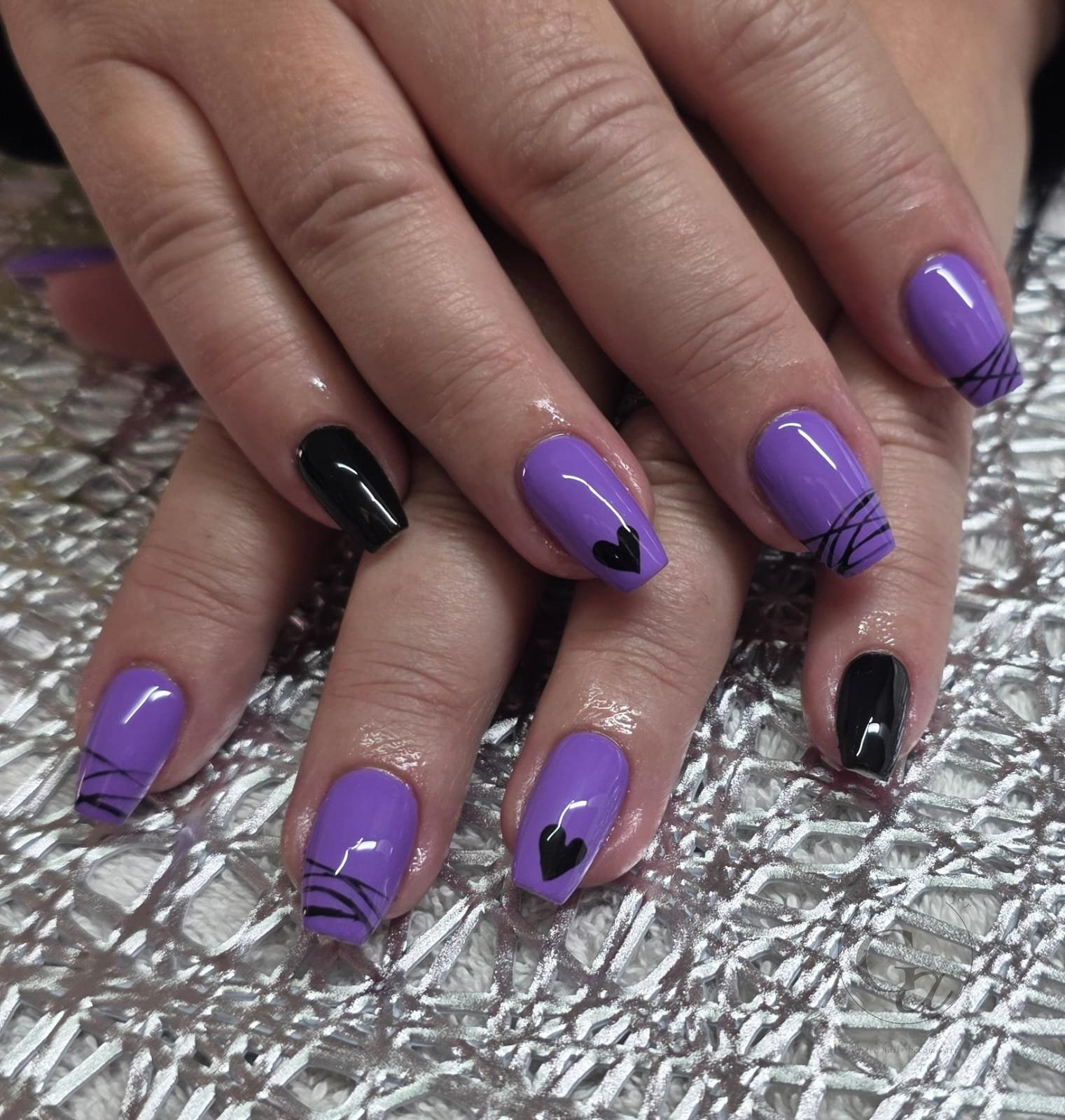 Purple square nails with hand-painted black hearts, line work and black accent nails.