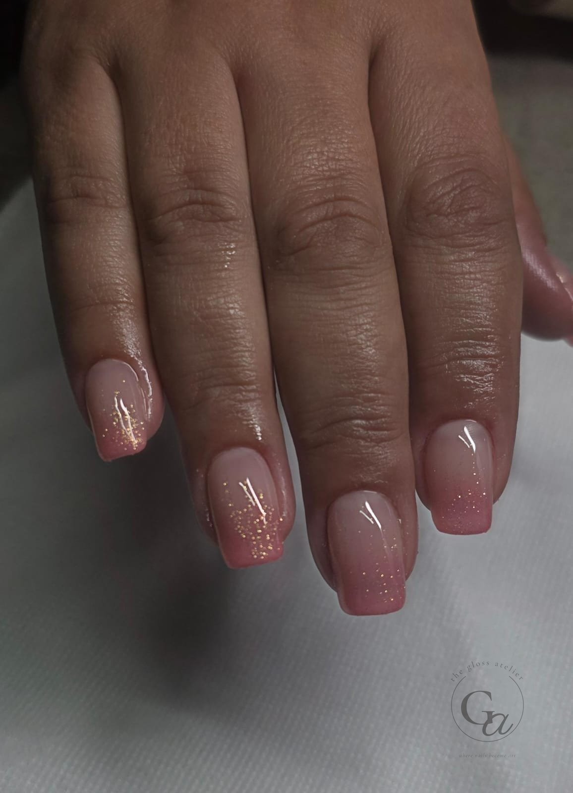Nude-to-pink baby-boomer ombré on square nails with gold glitter.