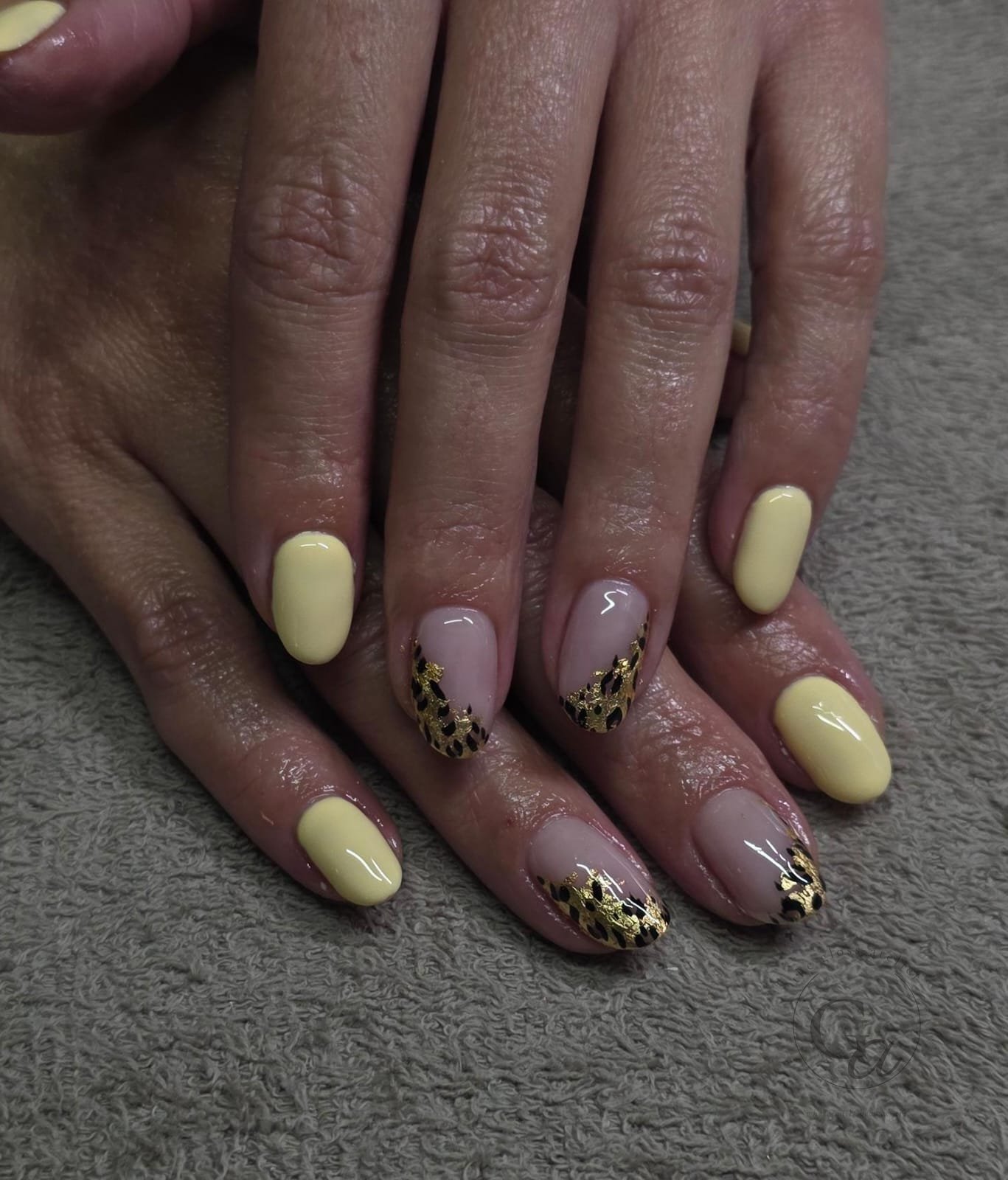 Butter-yellow nails with leopard-print French tips and gold leaf.