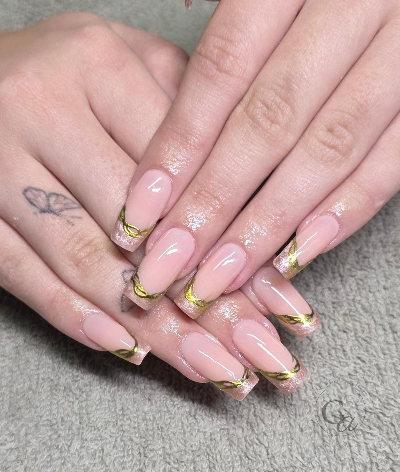 Long nude coffin nails with gold chrome swirl French tips.