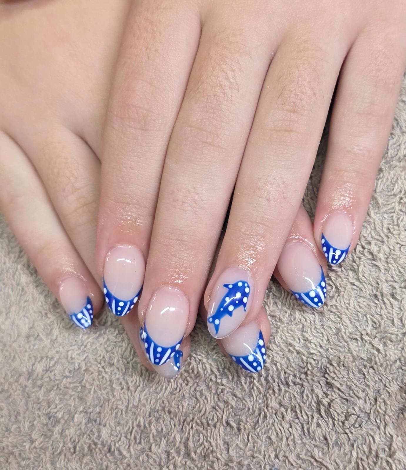 Cobalt blue and white French tips with a hand-painted dolphin accent nail.