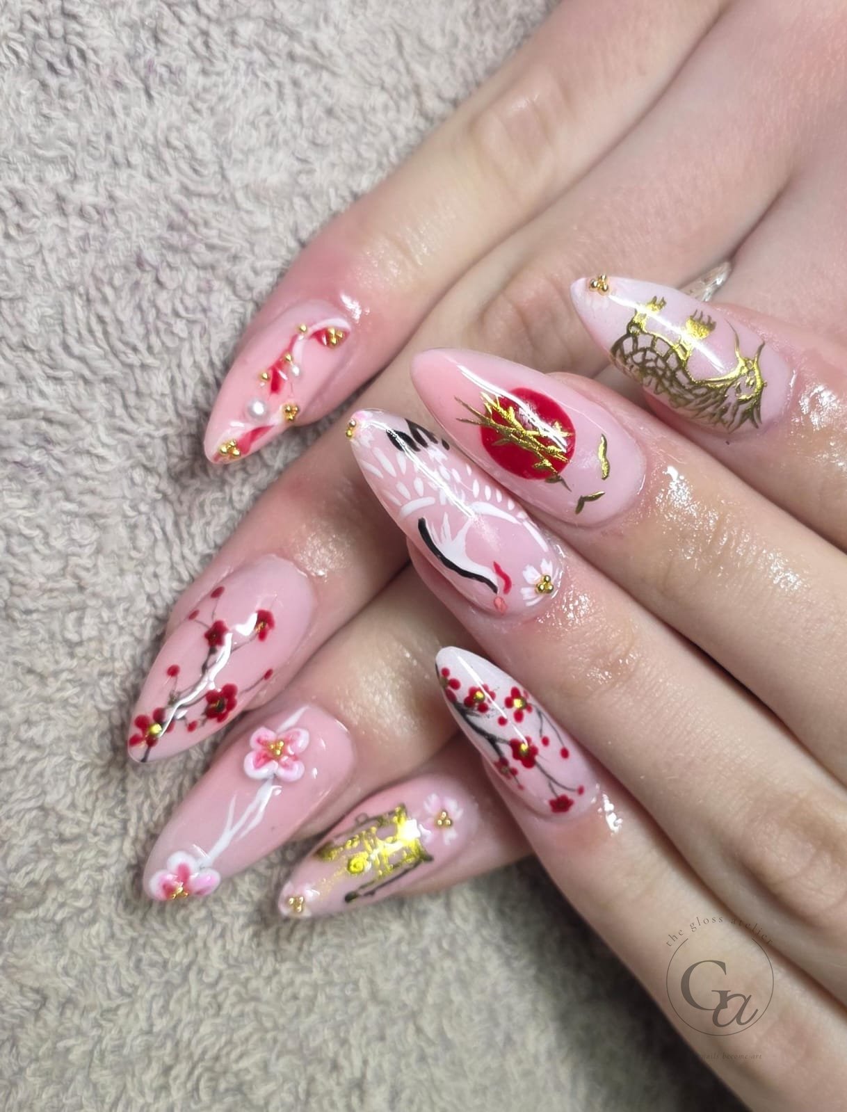 Cherry-blossom set on pink almond nails with sculpted 3D flowers, gold detail and a painted crane.