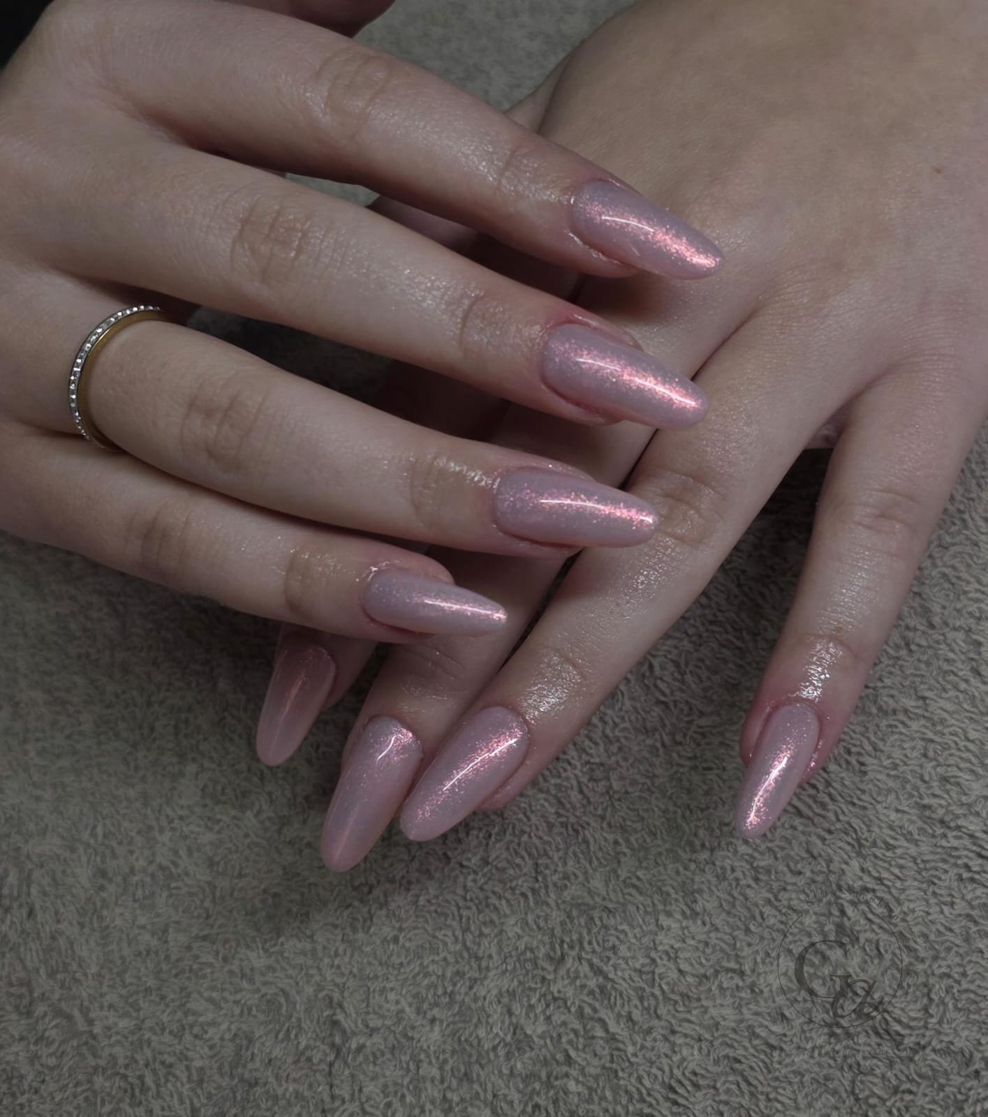 Pink pearl shimmer on long almond nails.
