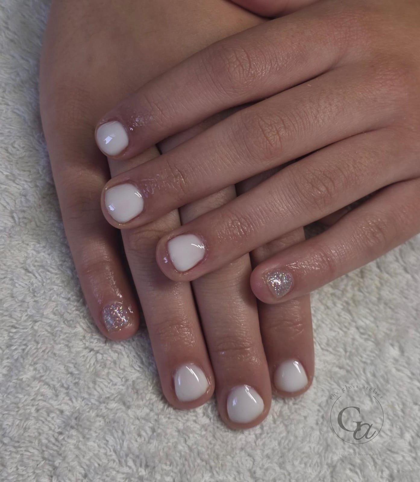 Short natural nails in milky white with silver glitter accent nails.
