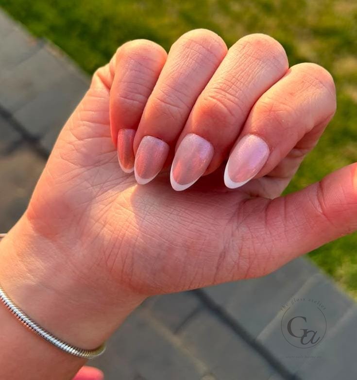 Pearl-shimmer almond nails with slim white French tips.