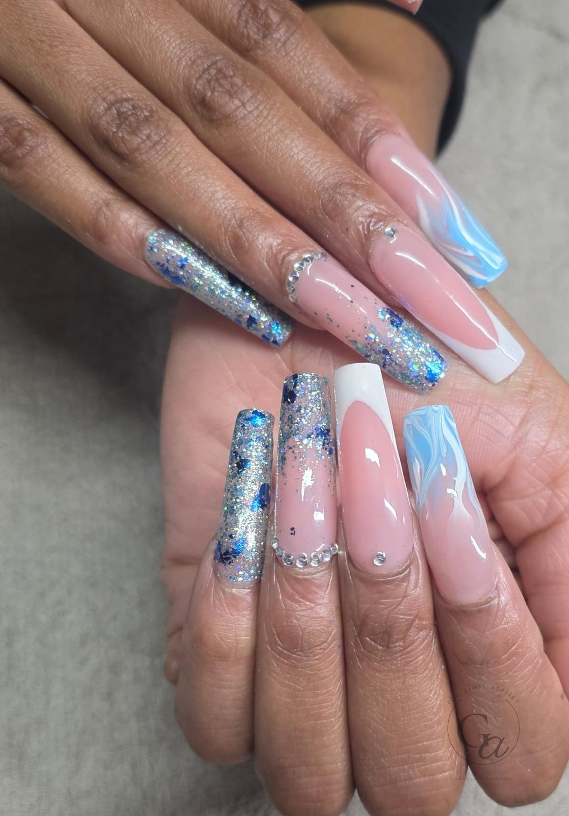 Long coffin nails in pink and white French with blue marble, silver glitter and crystals.